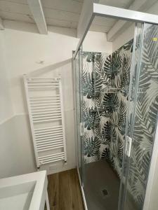 uma cabina de duche na casa de banho com papel de parede de planta em LOCANDA LA CAMPAGNOLA em Vignola
