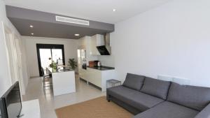 sala de estar con sofá y cocina en Luxe appartement met 2 badkamers / zee / zwembad, en Lo Pagán