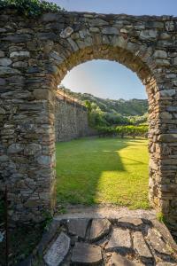 an arch in a stone wall with a field behind it at Agriturismo Buranco in Monterosso al Mare