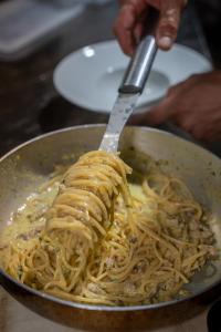 a person is eating pasta in a pan with a fork at Agriturismo Buranco in Monterosso al Mare