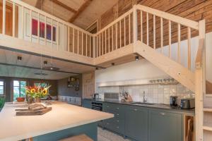 a kitchen with blue cabinets and a wooden ceiling at Landhaus Buchenberg in Rettenberg