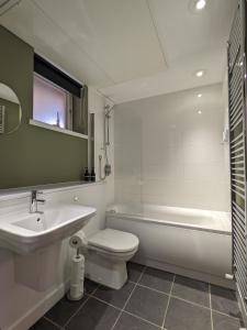 a bathroom with a sink and a tub and a toilet at Middlehaven Studio in Middlesbrough