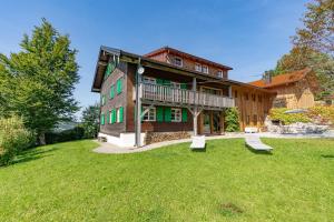 ein großes Haus mit grünem Rasen davor in der Unterkunft Landhaus Buchenberg in Rettenberg