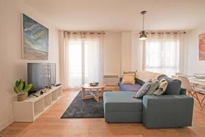 een woonkamer met een bank en een tv bij Appartement Cosy , Vue imprenable, Parking Privé in Montpellier