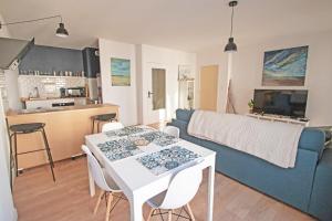 een woonkamer met een tafel en een blauwe bank bij Appartement Cosy , Vue imprenable, Parking Privé in Montpellier