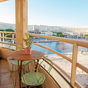 een tafel en stoelen op een balkon met uitzicht bij Appartement Cosy , Vue imprenable, Parking Privé in Montpellier