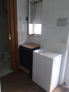 baño pequeño con lavadora y ventana en CENTRALISSIMO MINI APPARTAMENTO 2° PIANO, en Margherita di Savoia