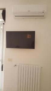 un televisor en una pared sobre un radiador en CENTRALISSIMO MINI APPARTAMENTO 2° PIANO, en Margherita di Savoia