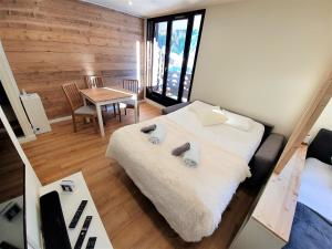 1 dormitorio con 1 cama grande y 1 mesa en Grand Studio Aiguille du Midi et vue Mont Blanc en Chamonix-Mont-Blanc