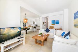 een woonkamer met een witte bank en een tv bij Villa Atlantis in Protaras
