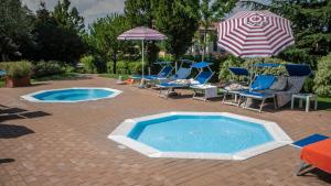 a swimming pool with chairs and an umbrella at Hotel Bella Italia in Peschiera del Garda