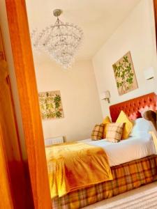 a bedroom with a bed and a chandelier at Oak Tree Inn in Brafferton