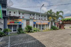 an empty parking lot in front of a hotel at Angrumba Family Homestay near RSUD Caruban Mitra RedDoorz in Mejayan