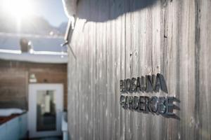 a sign on the side of a wooden building at Boutique & Gourmet Hotel Orso Grigio in San Candido