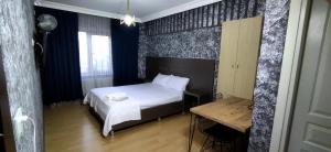 ein Schlafzimmer mit einem Bett und einem Tisch darin in der Unterkunft Zirkon Suit, Atasehir Otel, in Istanbul