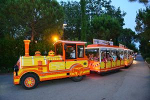 a yellow and red train with people riding in it at Hotel Bella Italia in Peschiera del Garda