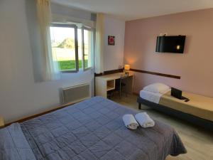 a bedroom with a bed and a desk and a television at Hôtel Azur Saint Junien Cit'Hotel in Saint-Junien