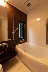a bathroom with a tub and a toilet and a sink at Hiraizumi Club -farm&resort- Vacation Stay in Hiraizumi