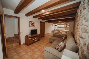 a living room with a couch and a tv at Ca La Leonor, Ecoturisme Terra Alta in Bot