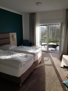 um quarto de hotel com duas camas e uma varanda em Boardinghouse am Borkumkai em Emden