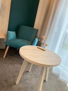 een houten tafel naast een stoel en een bank bij Boardinghouse am Borkumkai in Emden
