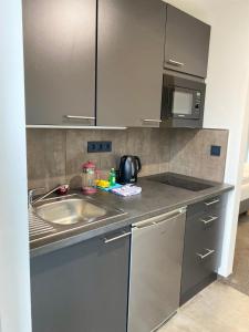 a kitchen with a sink and a microwave at Boardinghouse am Borkumkai in Emden