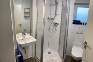 a bathroom with a shower and a sink and a toilet at Boardinghouse am Borkumkai in Emden