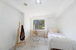1 dormitorio con cama, escritorio y ventana en Cliff Haven Retreat, en Katoomba