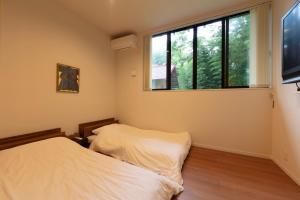 a bedroom with a bed and a large window at Hiraizumi Club -farm&resort- Vacation Stay in Hiraizumi