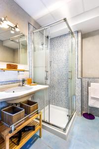 a bathroom with a glass shower and a sink at Genteel Home Francos in Seville