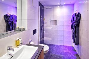 Fioletowa łazienka z umywalką i toaletą w obiekcie Active Nature Resort DAS SeeMOUNT w mieście See