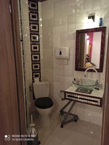 a bathroom with a toilet and a sink and a mirror at Gościnne Gniazdo in Będzin