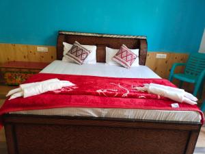 um quarto com uma cama com um cobertor vermelho em LA-TSAS GUEST HOUSE em Hundar