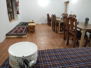 a dining room with a table and a table and chairs at LA-TSAS GUEST HOUSE in Hundar
