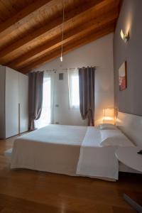 Un dormitorio con una gran cama blanca y una ventana en Magrine Castelfranco Veneto en Castelfranco Veneto