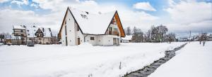 una iglesia está cubierta de nieve en una ciudad en Tojemoje, en Białka Tatrzanska