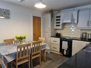 a kitchen with a table and chairs and a kitchen with white cabinets at The Townhouse, Derry City Centre. in Derry Londonderry +7 photos