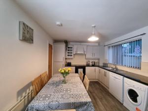 a kitchen with a table with a vase of flowers on it at The Townhouse, Derry City Centre. in Derry Londonderry