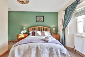 a bedroom with a bed and a green wall at Swallows Nest Bed and Breakfast in Clapham