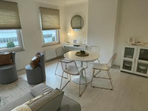 een woonkamer met een bank en een tafel en stoelen bij Le Relax by La Dame de Coeur - Logement zen urbain in Namen