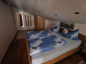 Un dormitorio con una cama con sábanas azules y bichos. en Lamplhof, en Wiesing