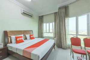 Super OYO 111 Al Thabit Hotel في صور: غرفة نوم بسرير ونافذة كبيرة