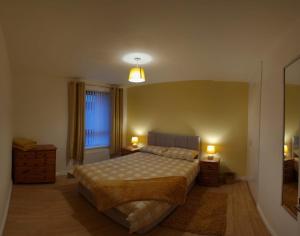 a bedroom with a bed and two lamps and a window at The Townhouse, Derry City Centre. in Derry Londonderry