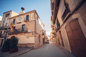 Une allée avec une horloge sur le côté d'un bâtiment dans l'établissement Ca La Leonor, Ecoturisme Terra Alta, à Bot