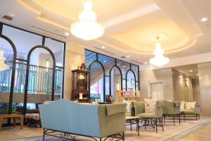 a lobby with chairs and a clock and windows at Hotel Rose Garden Shinjuku in Tokyo