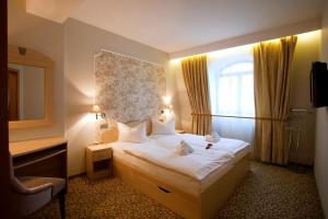 a hotel room with a bed with two teddy bears on it at Hotel Ambiente Wellness & Spa in Karlovy Vary