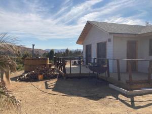 une petite maison avec une terrasse et un grill dans l'établissement CABAÑA DE CAMPO, à Cuncumén