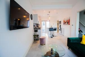 a living room with a green couch and a glass table at Surbiton Luxury Garden House 19A in Surbiton