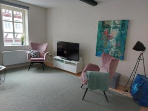a living room with two chairs and a television at Denkmal in Melsungen