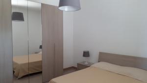 a bedroom with a bed and a mirror at Le Pigne casa vacanze. in Pollica